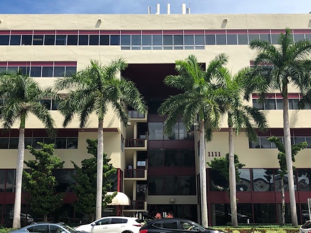 Front of a commercial building with palm trees